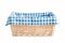 Straw basket with checked linen isolated.