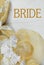 A straw bonnet and white and ivory silk flowers on a rustic wooden white washed background