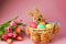 Straw bunny basket with easter colorful eggs und fresh tulips on pink background. Happy Easter card. Close up