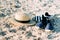 Straw hat and espadrilles lying on the sand on the beach. Summer concept. Holiday relaxing, beach vacation.