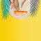 Straw hat with orange sunglasses and tropical leaves on yellow background, top view. Summer holiday concept. Tropical vacation .