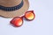 Straw hat and red sunglasses on white background. Vacation time. Traveling concept. Your text space.