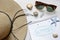 Straw hat, seashells, sunglasses and notebook on white table