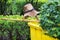 A straw hat, simple Thai broom and a yellow garbage bin; all abandoned quickly because of a sudden summer rainstorm.