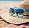 straw hat and sunglasses on the beach sand