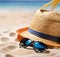 straw hat and sunglasses on the beach sand