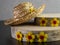 Straw hat on top of birch tree pieces of wood decorated with yellow flowers
