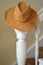 Straw hat on white stair rail banister