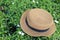 A straw panama style hat on green plant background