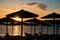 Straw parasols on a beach at sunset in Sithonia