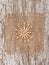 Straw snowflake on the burlap textile and old wood