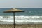 Straw umbrella in front of stormy sea