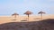 Straw umbrella on peaceful beach with blue sea and sky background