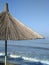 Straw umbrellas against a blue sky. Parasols