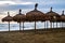 Straw umbrellas on the dirty beach on stormy day