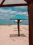 Straw umbrellas on green grass harsh shadow, sand beach vivid blue sea water sky background sunbeam. Scenic landscape