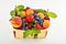 Strawberries, apricots, blueberries, peach in basket isolated on