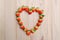 Strawberries array heart shape on wooden table