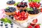 Strawberries, blueberries, blackberries tartlets with chocolate ganache, fresh berries and mint leaves. Fresh fruit tart, freshly