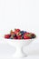 Strawberries and Blueberries in White Bowl over Timber Panel Background
