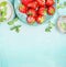 Strawberries border with mint and sugar on turquoise shabby chic background, top view