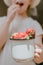 Strawberries in children hands. Girl child holding fresh red organic strawberries in white enameled cup. Summer vitamins