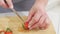 strawberries are cut into pieces on a wooden cutting board to decorate desserts.