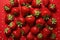 strawberries of different shapes on a red background created with Generative Al technology