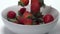 Strawberries falling into a bowl in slow motion