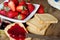 Strawberries jam with rusk on wooden table