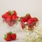 Strawberries in a jelly glass on a white background.