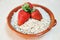 Strawberries and oat flakes in an earthenware bowl