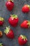 Strawberries ripe on a dark black beton background.