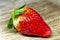 Strawberries. Strawberry resting on a brown textured trunk.