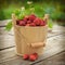 Strawberries in wooden bucket bloomi Fresh, juicy red strawberries in a wooden small bucket, stands on a wooden natural table