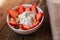 Strawberries with yogurt seeds pumpkin seeds chia sunflower seeds and apple in a white bowl on a wooden table