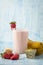 Strawberry and banana cold smoothie on blue background