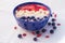 Strawberry banana smoothie bowl topped with strawberries bananas, coconut, blueberries and goji berries