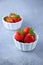 Strawberry berries in a white bowl on a concrete table. Place for text. Strawberries in a plate - dessert. Healthy food.