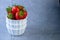 Strawberry berries in a white bowl on a concrete table. Place for text. Strawberries in a plate - dessert. Healthy food