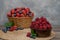 Strawberry and blueberry in basket and raspberries in bowl on wood table. Fresh berries