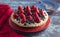 A Strawberry and Blueberry Fresh Summer Pie on a Distressed Blue Wooden Table