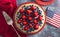 A Strawberry and Blueberry Fresh Summer Pie on a Distressed Blue Wooden Table