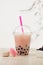 Strawberry Boba Bubble Tea with macaron and ice.