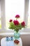 Strawberry, book, bouquet of beautiful peonies and two cups of coffee on white table