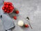 Strawberry in a bowl, whipped cream, teaspoon and linen napkin on a gray background.