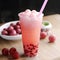 Strawberry Bubble tea or a bubble milk tea in disposable tall plastic cup with drinking straw. Tea-based drink with vegan milk,