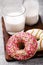 Strawberry and caramel donut with milk on a wooden stand