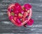 Strawberry, cherry, blueberry plate heart, fresh vintage appetizing flower rose on a black wooden background