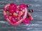Strawberry, cherry, blueberry plate heart, vintage appetizing flower rose on a black wooden background